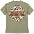 Back of khaki T-shirt with a large circular Cow Creek Apparel logo in brown, green, and cream camouflage.
