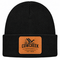 Black knit beanie with fold-over cuff and Cow Creek Apparel leather patch